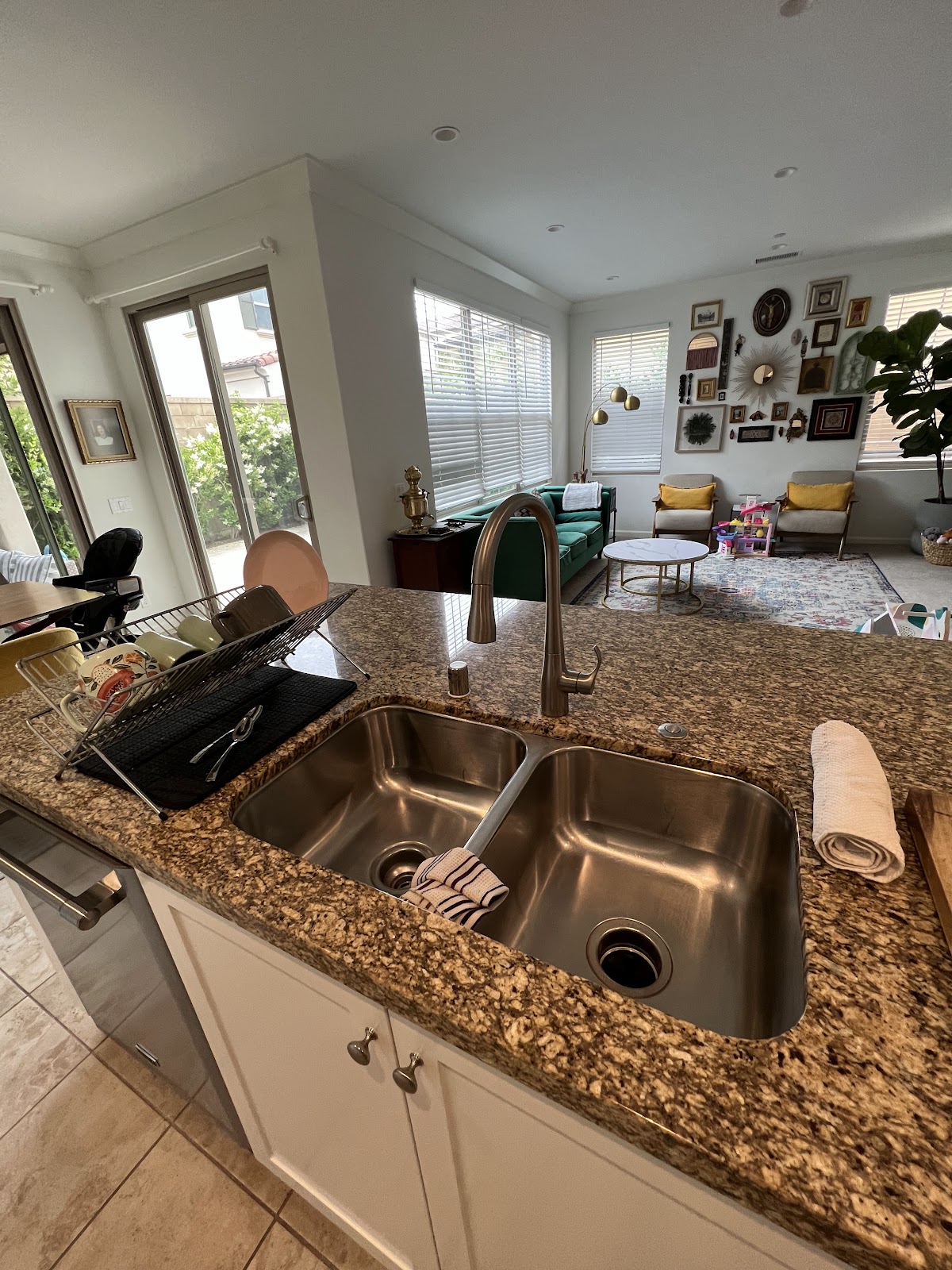 View of a kitchen sink with adjacent living area.